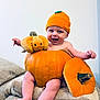 baby, pumpkin, orange, hat, smile, happy, plush_toy, blanket, cute, infant, child, autumn, seasonal, sitting, cozy, indoor, face, legs, headwear, playful