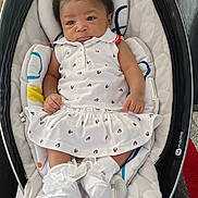 Aiyanna joined the competition — help win amazing prizes! baby, infant, child, white_dress, baby_rocker, cushion, hair_clips, socks, frilly_socks, cute, indoor, carpet, patterned_clothing, infant_fashion, seated, portrait, small_hands, soft_toys, comfortable, resting