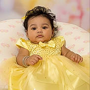Deanna is registered to the contest to win money with this photo: adorable, baby, bracelet, celebration, child, closeup, curly_hair, cushion, cute, fashion, happy, indoor, infant, pink_butterflies, portrait, seated, soft_lighting, white_shoes, yellow_dress, young_child