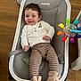 baby, child, infant, smiling, baby_seat, toy, colorful, floor, wooden_floor, clothing, striped_pants, slippers, bunny_slippers, happy, indoor, cushion, comfort, seat, person, cute
