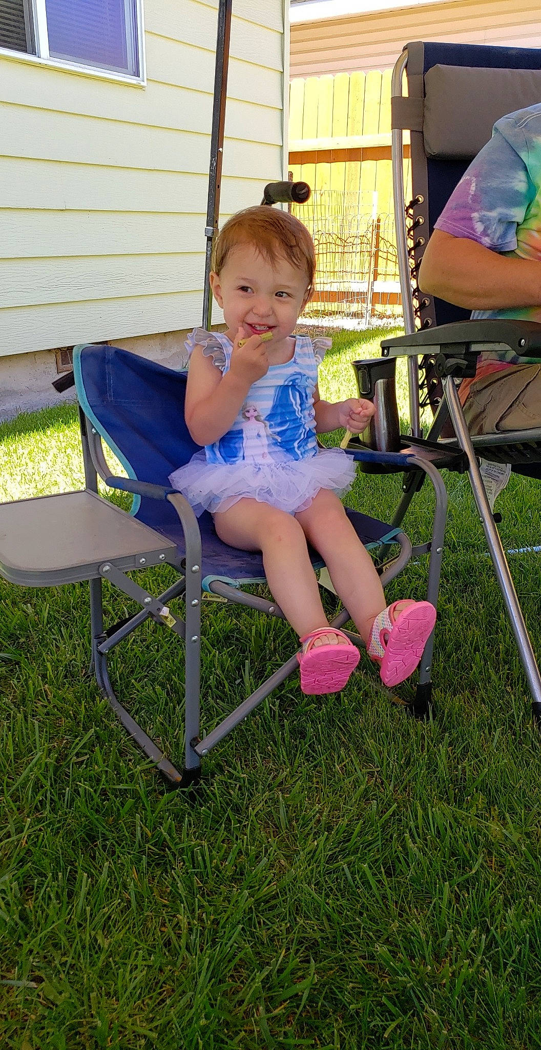 Evelynn joined the competition — help win amazing prizes! baby_toddler_clothing, chair, child, folding_chair, foot, fun, furniture, grass, happy, joy, lap, leisure, outdoor_furniture, person, recreation, shorts, sitting, smile, t_shirt, toddler