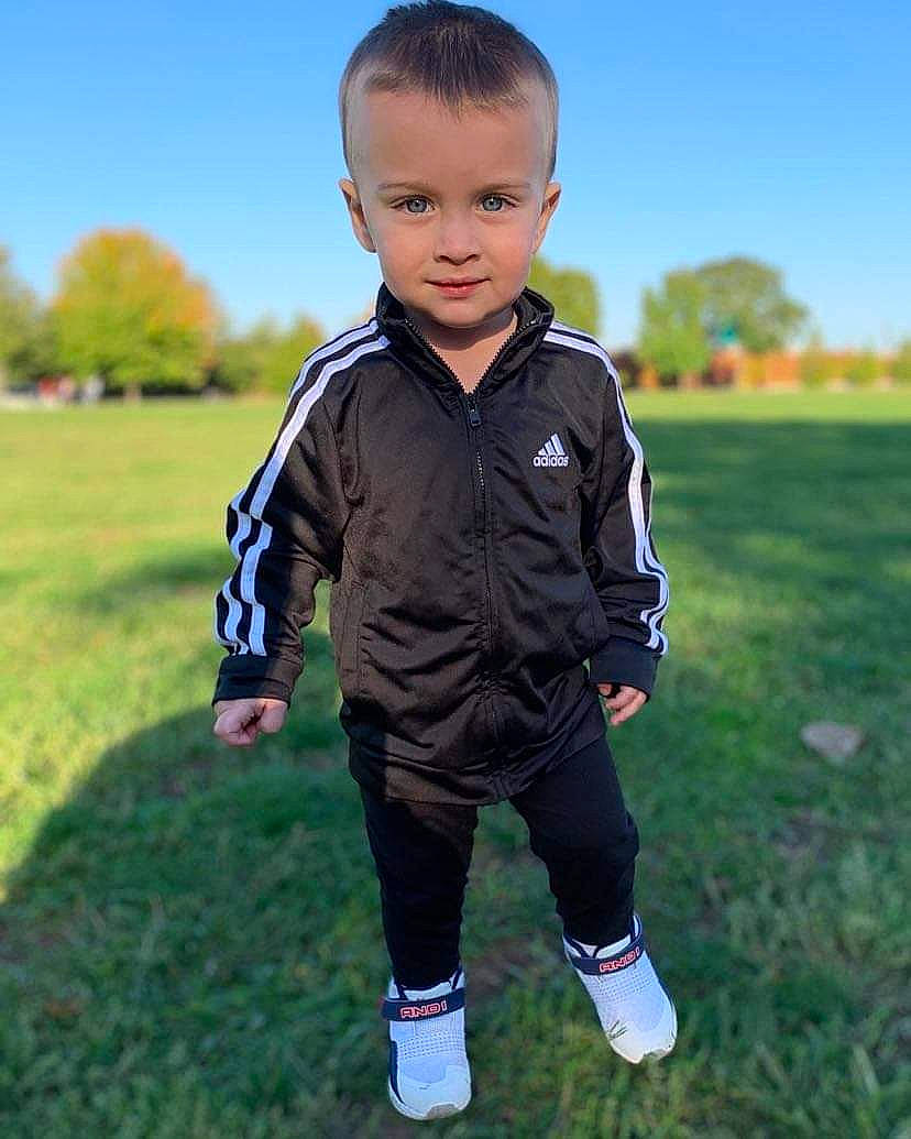 Nicholas Jr is registered to the contest to win money with this photo: baby_toddler_clothing, child, electric_blue, fun, grass, grassland, happy, landscape, people_in_nature, person, player, portrait_photography, prairie, sitting, sky, sleeve, sportswear, t_shirt, toddler, tree