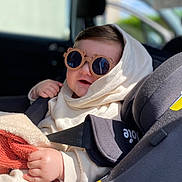 Emin a rejoint le concours — aidez-le/la à gagner de superbes lots ! baby, child, car_seat, sunglasses, hoodie, blanket, hand, face, smiling, seatbelt, indoor, car_interior, cozy, cute, sunlight, portrait, infant, clothing, seat, person