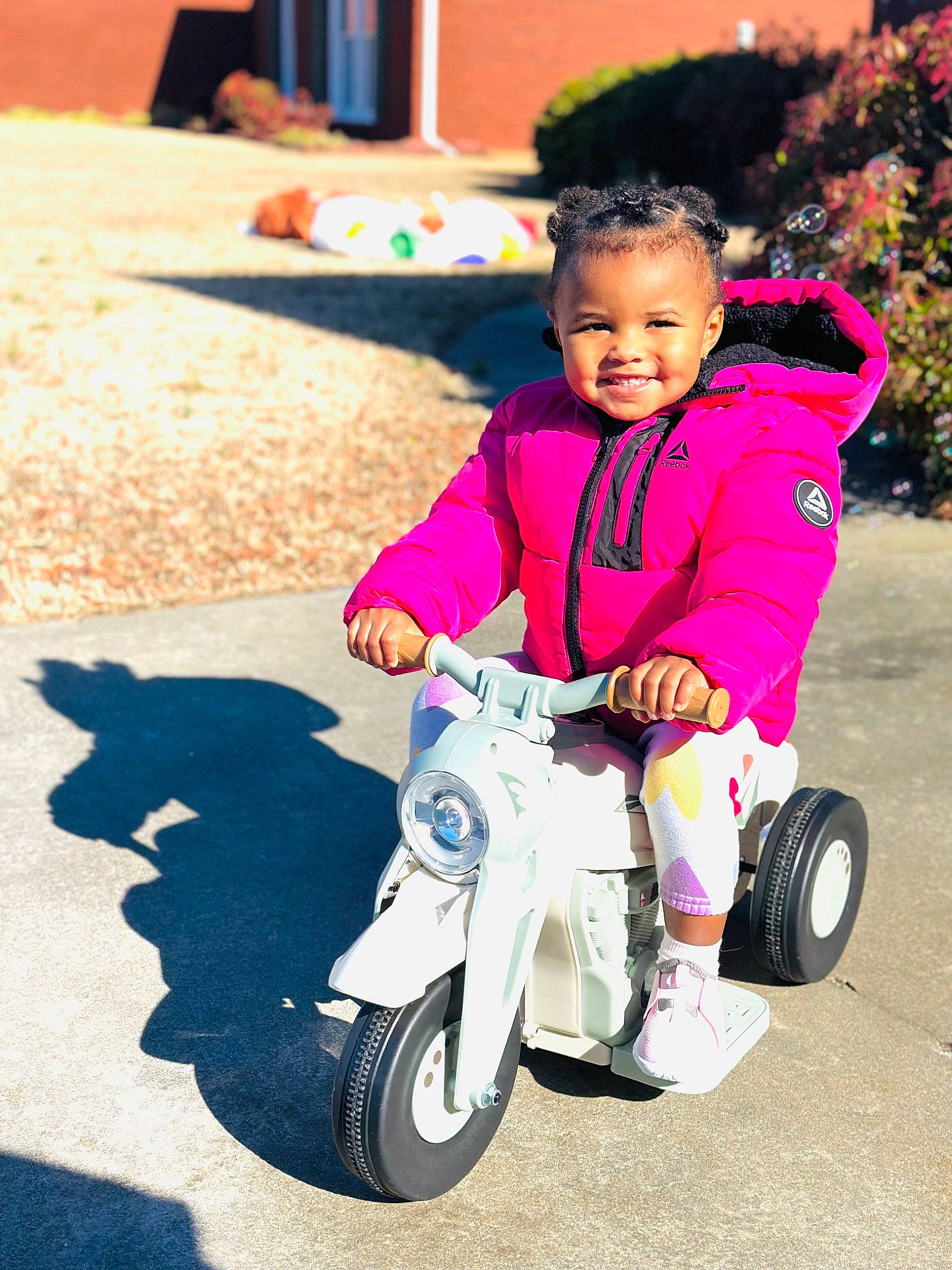 Milani joined the competition — help win amazing prizes! automotive_tire, automotive_wheel_system, baby_toddler_clothing, bicycle_accessory, child, electric_blue, fun, happy, joy, leisure, magenta, mode_of_transport, person, public_space, recreation, riding_toy, rolling, smile, tire, toddler