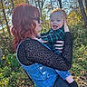 Howard is registered to the contest to win money with this photo: baby, child, adult, parent, holding, smiling, laughing, outdoor, autumn, forest, trees, leaves, sunlight, portrait, family, red_hair, sunglasses, plaid_shirt, denim, woodland