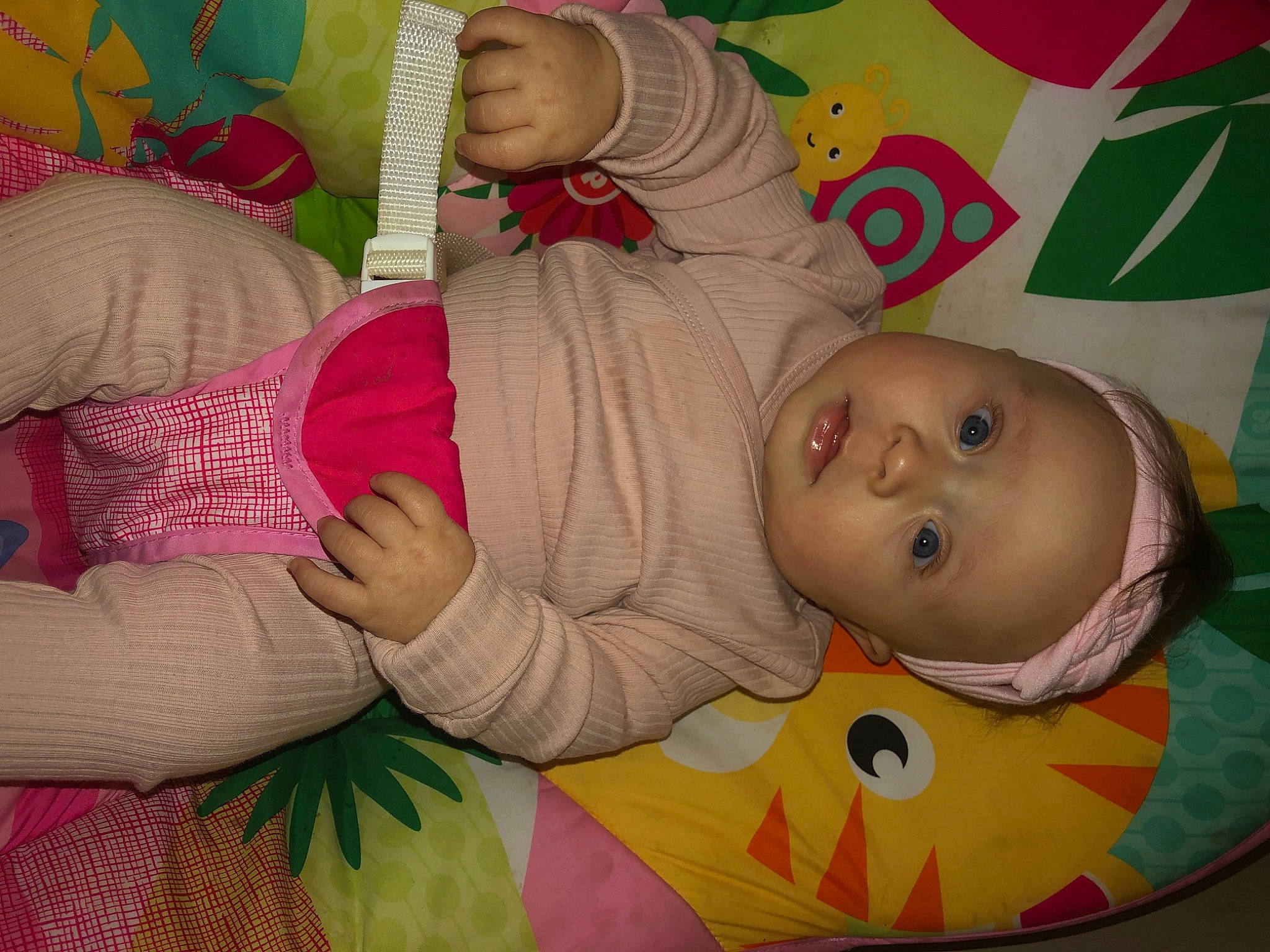 Nova is registered to the contest to win money with this photo: baby, baby_products, baby_toddler_clothing, cheek, child, comfort, eye, facial_expression, flooring, happy, iris, linens, mammal, mouth, nose, person, pink, product, room, skin