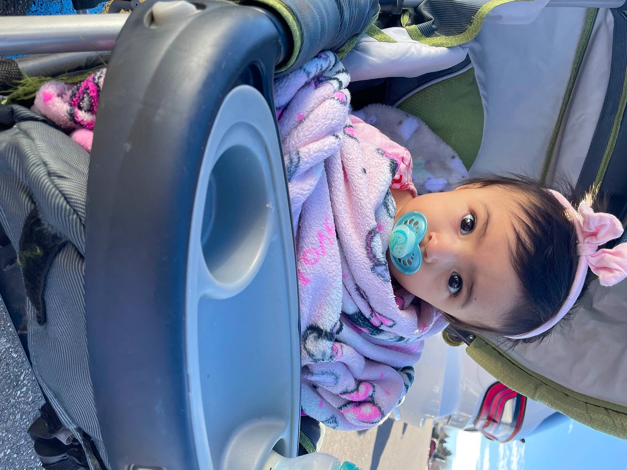 Amora is registered to the contest to win money with this photo: alloy_wheel, auto_part, automotive_design, automotive_tire, baby, child, fender, fun, helmet, hubcap, motor_vehicle, person, pink, public_space, purple, synthetic_rubber, tire, toddler, tread, vehicle