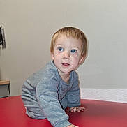 Joshua joined the competition — help win amazing prizes! blue_eyes, child, crawling, curious, face, floor, furniture, gray_clothing, hand, indoor, person, red_surface, shelf, short_hair, skin, sleeve, toddler, utensil_holder, wall, young_child