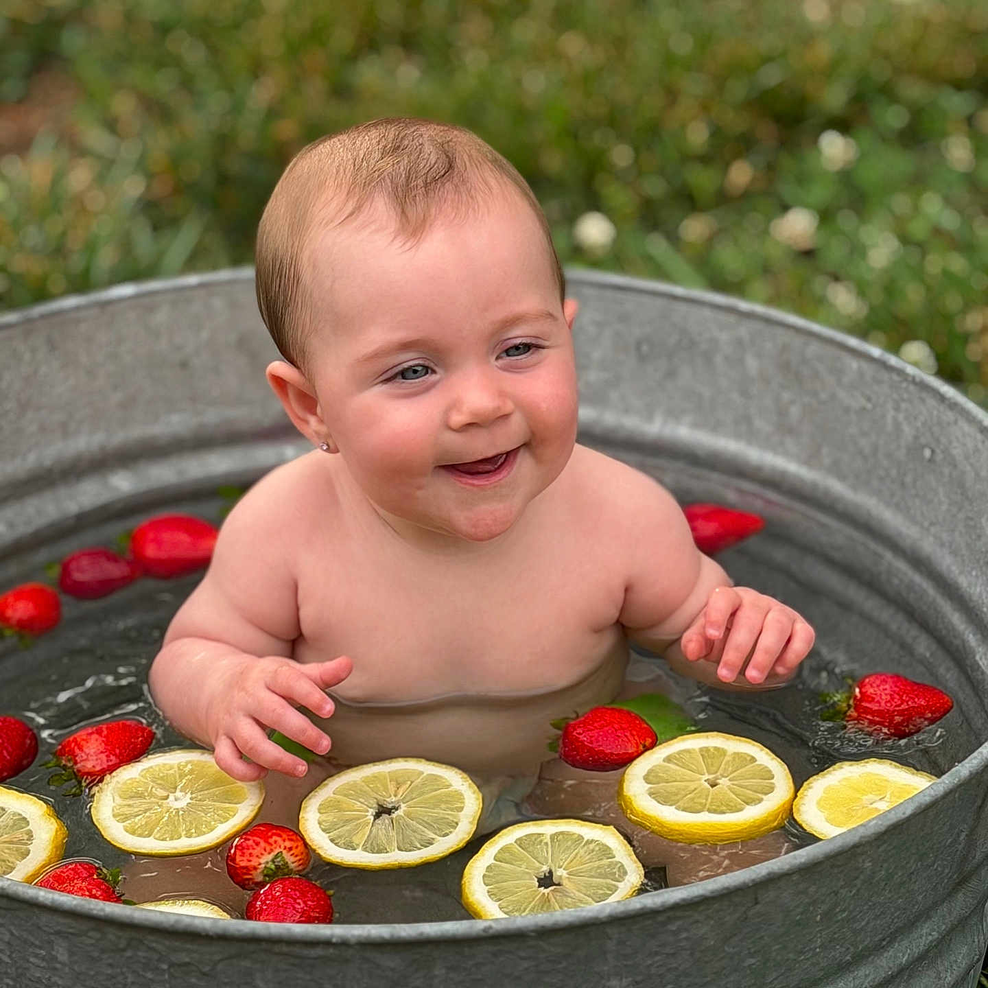 Blakleigh is registered to the contest to win money with this photo: baby, child, metal_tub, water, lemon_slices, strawberries, outdoor, grass, happy, smiling, summer, fruit, nature, cute, skin, playful, portrait, fresh, relaxing, bath