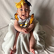 Blakleigh joined the competition — help win amazing prizes! baby, child, smiling, headband, yellow_bow, navy_bow, blanket, white_blanket, polka_dot, outfit, sitting, happy, infant, portrait, cute, face, arms, legs, soft_texture, indoor