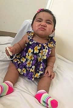 Royalty is registered to the contest to win money with this photo: baby_toddler_clothing, child, comfort, finger, fun, happy, human_leg, knee, leg, magenta, neck, person, pink, purple, sitting, skin, sleeve, sock, thigh, thumb