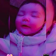 Freya is registered to the contest to win money with this photo: baby, infant, sleeping, smile, face, portrait, purple_filter, heart_emoji, sticker, blanket, onesie, closeup, framed_photo, couch, cozy, soft_lighting, head, hair, cheeks, pink_tint