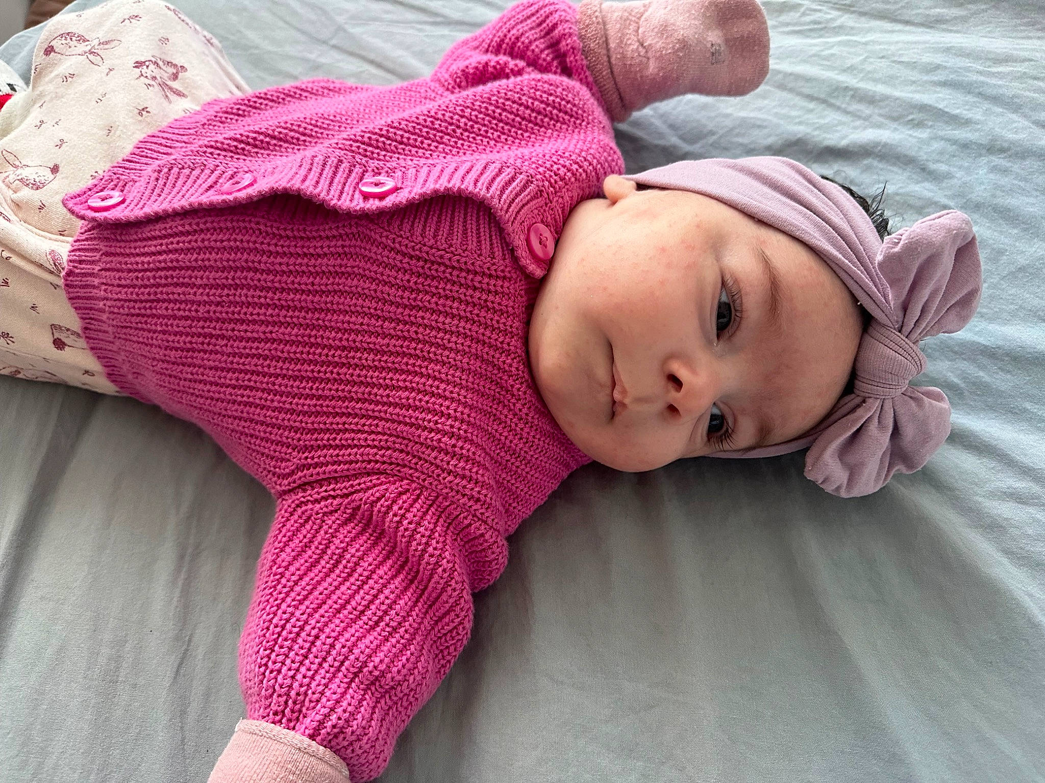 Eva a rejoint le concours — aidez-le/la à gagner de superbes lots ! baby, baby_toddler_clothing, comfort, fashion_accessory, flooring, happy, head, headwear, human_body, knit_cap, linens, magenta, pattern, person, pink, purple, skin, sleeve, textile, toddler