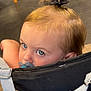 toddler, child, blue_eyes, pacifier, hair_bow, ponytail, stroller, indoor, wood_floor, furniture, close_up, face, cute, young_child, baby, head, people, portrait, infant, seat