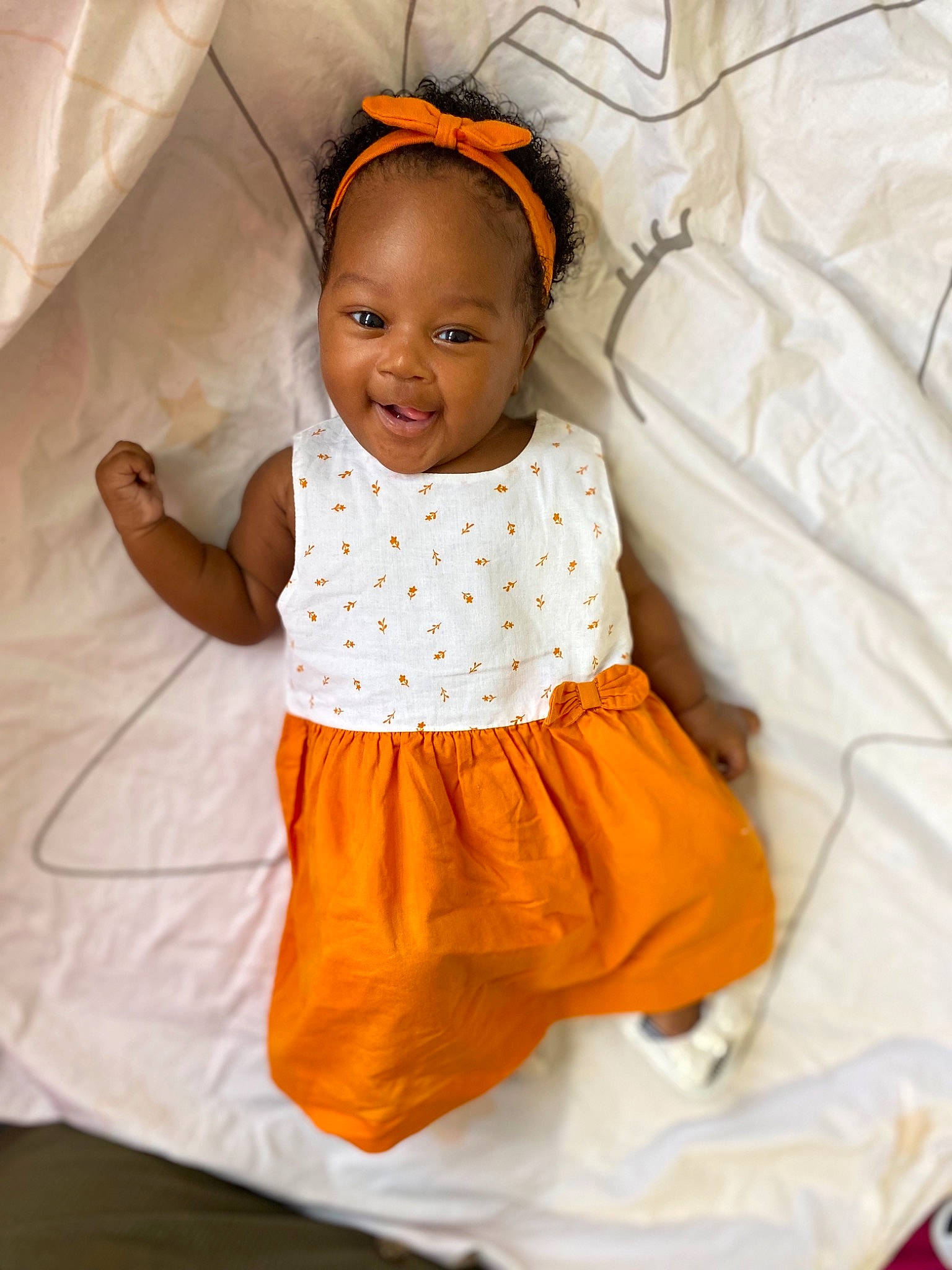 Lynaël a rejoint le concours — aidez-le/la à gagner de superbes lots ! arm, baby, baby_toddler_clothing, clothing, comfort, eye, face, hand, happy, head, human_body, joy, neck, orange, outerwear, person, product, skin, sleeve, smile