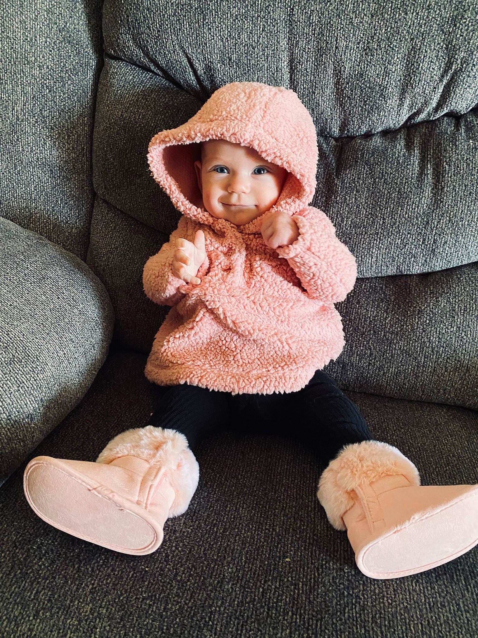Lydia is registered to the contest to win money with this photo: baby, baby_toddler_clothing, beige, cheek, child, comfort, dress, flooring, foot, fur, headwear, human_body, knit_cap, lap, linens, person, product, sitting, sleeve, toddler