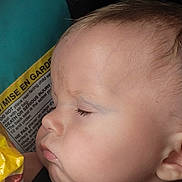 Remington is registered to the contest to win money with this photo: baby, closeup, face, profile, sleeping, child, infant, cheeks, skin, head, ear, eyelashes, expression, peaceful, indoors, warning_label, text, colorful, soft_light, portrait