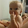 baby, child, diaper, indoor, curly_hair, finger_in_nose, smiling, playful, person, skin, face, head, expression, young_child, peeking, background, room, wall, bare_chest, family