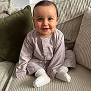 Jessim a rejoint le concours — aidez-le/la à gagner de superbes lots ! baby, child, smiling, couch, cushion, indoor, clothing, socks, happy, portrait, seated, person, home, cute, infant, soft_lighting, cozy, fabric, face, toddler