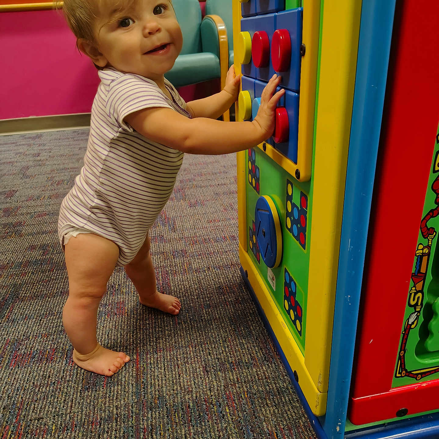 Aurora joined the competition — help win amazing prizes! baby, barefoot, buttons, carpet, child, colorful, curious, floor, furniture, happy, indoor, person, play_structure, playground, smile, standing, striped_clothing, toddler, toy, young_child