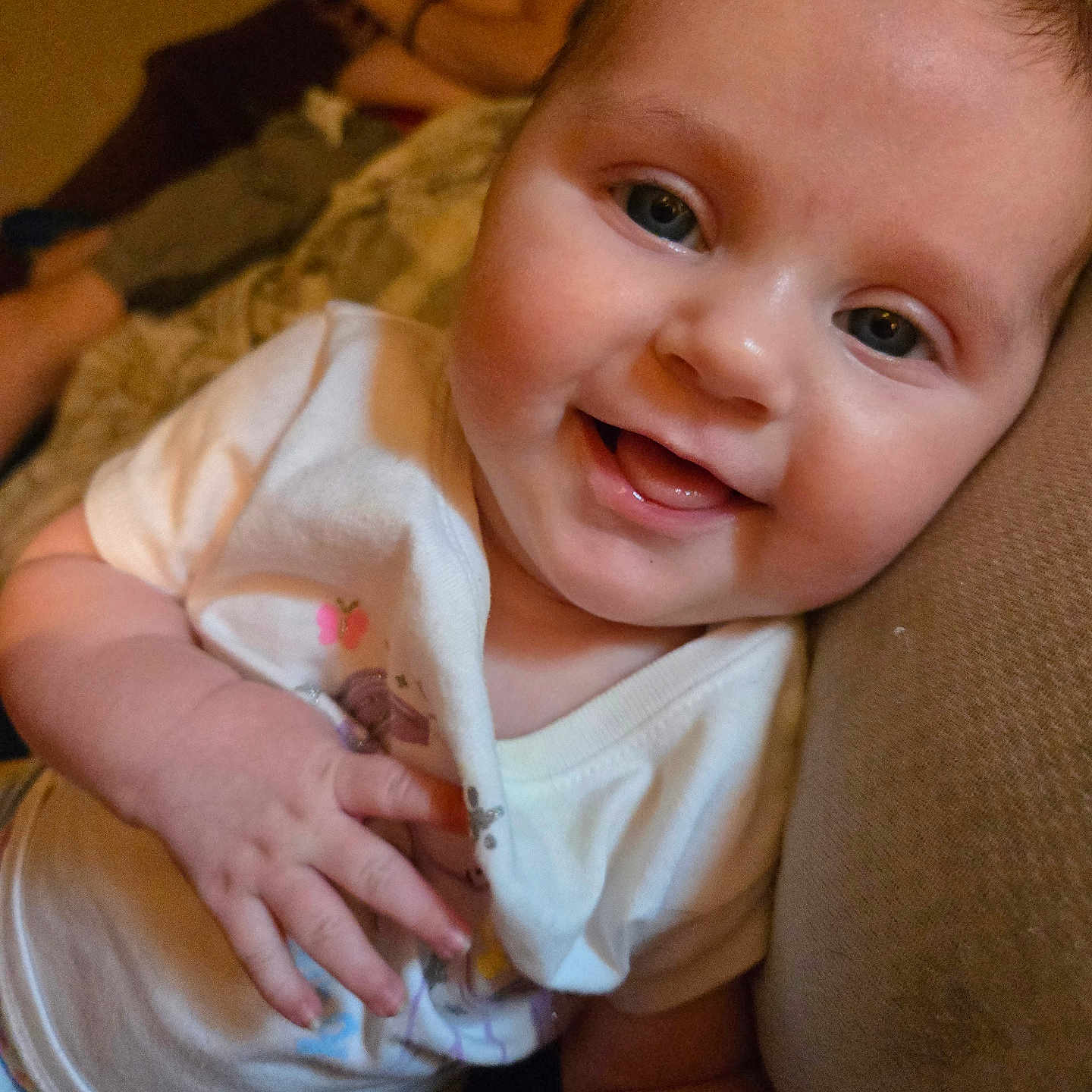 Aurora is registered to the contest to win money with this photo: adult, baby, background, casual, child, closeup, clothing, colorful, couch, face, hand, happy, indoor, infant, person, phone, portrait, relaxing, sitting, smiling