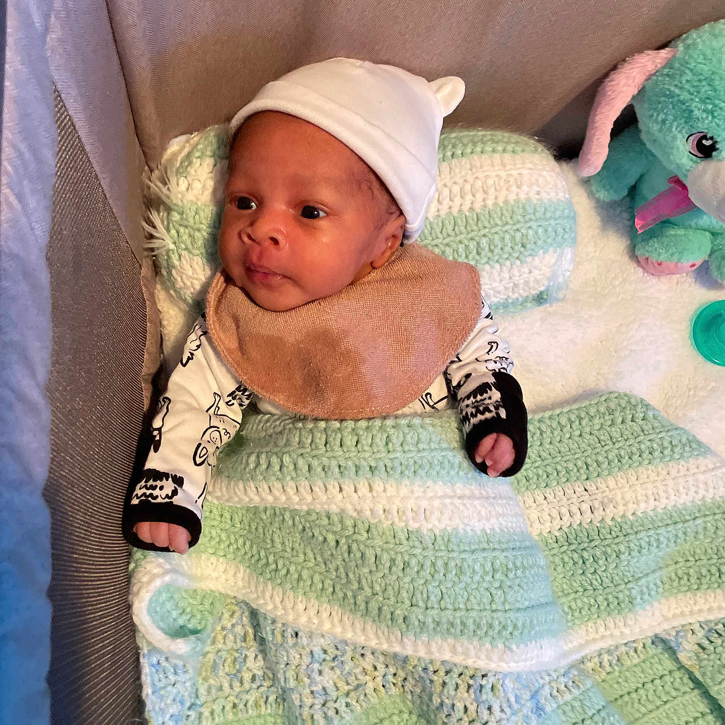 Chozen is registered to the contest to win money with this photo: baby, blanket, child, clothing, cozy, crib, cute, hat, headwear, indoors, infant, knit, pacifier, person, plush_toy, portrait, rabbit, resting, sleeping_area, soft_texture