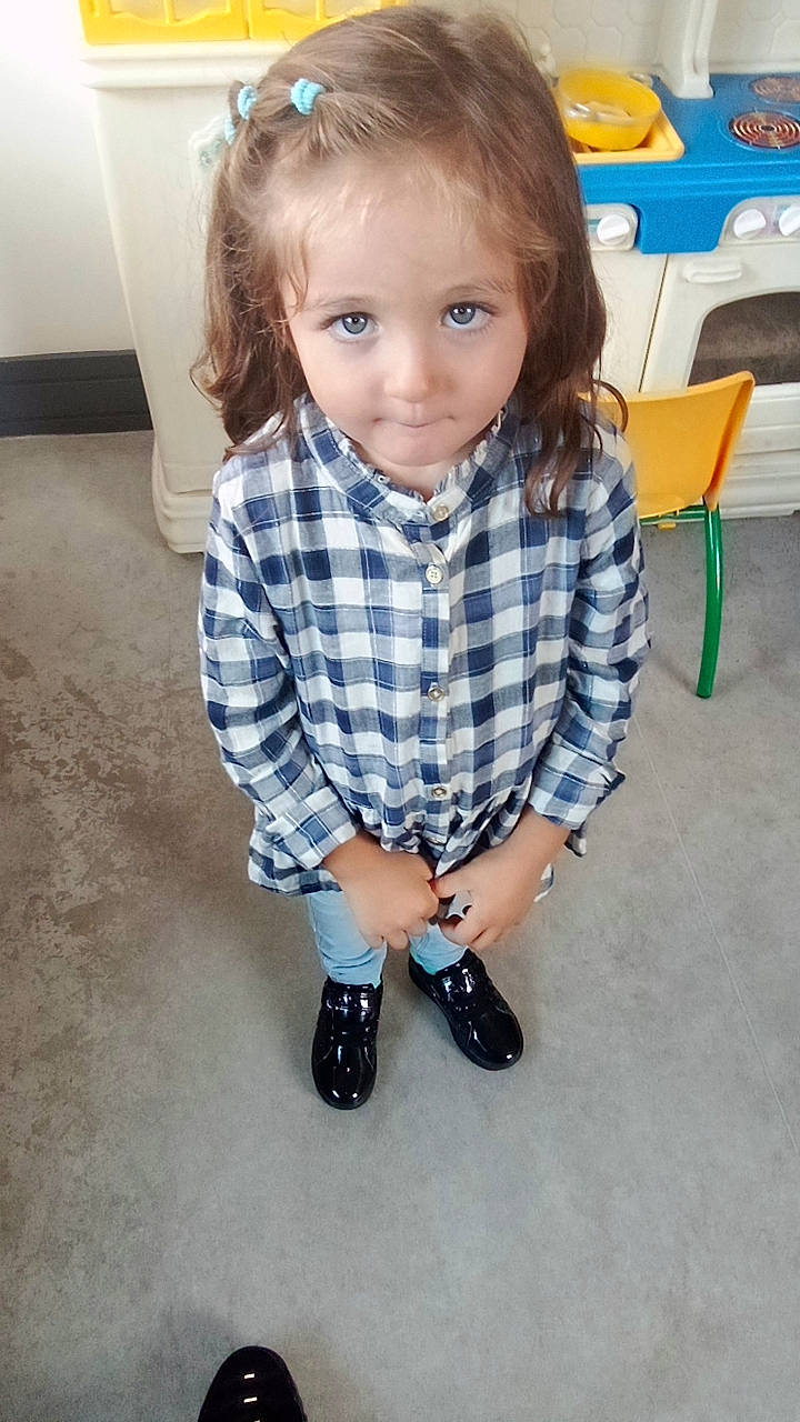 Maïssa a rejoint le concours — aidez-le/la à gagner de superbes lots ! blond, child, collar, dress_shirt, electric_blue, face, flooring, fun, hair, head, human_leg, knee, pattern, person, plaid, sitting, sleeve, sock, tartan, toddler