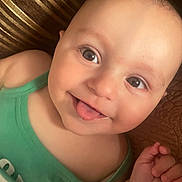 Arda participe au concours pour gagner de l'argent avec cette photo : baby, child, face, tongue_out, green_clothing, close_up, smiling, cute, skin, hand, infant, portrait, eyes, expression, lying_down, one_person, indoors, playful, happy, baby_skin