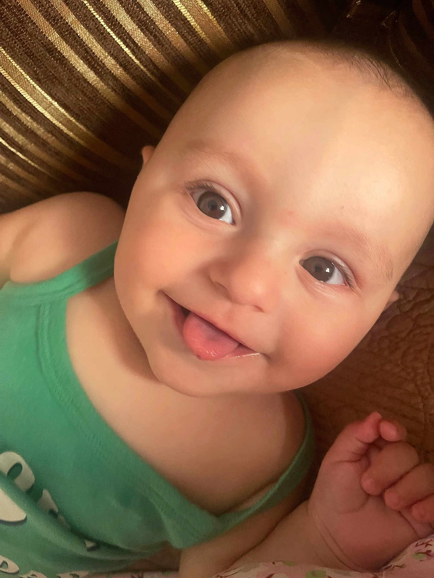 Arda participe au concours pour gagner de l'argent avec cette photo : baby, child, face, tongue_out, green_clothing, close_up, smiling, cute, skin, hand, infant, portrait, eyes, expression, lying_down, one_person, indoors, playful, happy, baby_skin