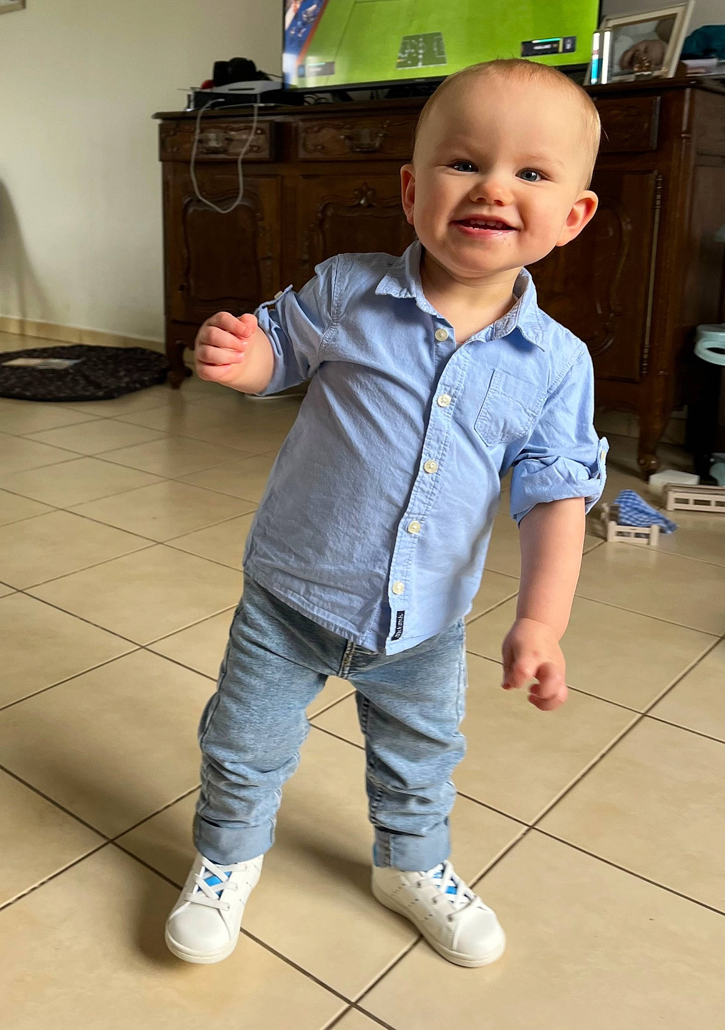 Alessio participe au concours pour gagner de l'argent avec cette photo : baby_toddler_clothing, cheek, child, dress_shirt, eye, floor, flooring, fun, happy, hardwood, joint, joy, person, shoulder, skin, sleeve, smile, standing, television, thumb