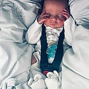 Enzo participe au concours pour gagner de l'argent avec cette photo : baby, sleeping, blanket, onesie, pacifier, plush_booties, infant, hands, face, cozy, white, cute, closeup, comfort, newborn, soft, resting, child, peaceful, indoor