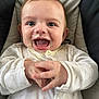 baby, child, messy, food, laughing, happy, white_clothing, cushion, seat, hands, face, mouth_open, eyes, infant, cute, portrait, indoors, closeup, smiling, joyful