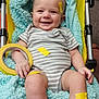 baby, infant, stroller, blanket, tape, roll_of_tape, yellow_tape, blue_blanket, smiling, onesie, striped_clothing, legs, feet, hand, chubby_legs, indoor, cozy, seat, happy, portrait
