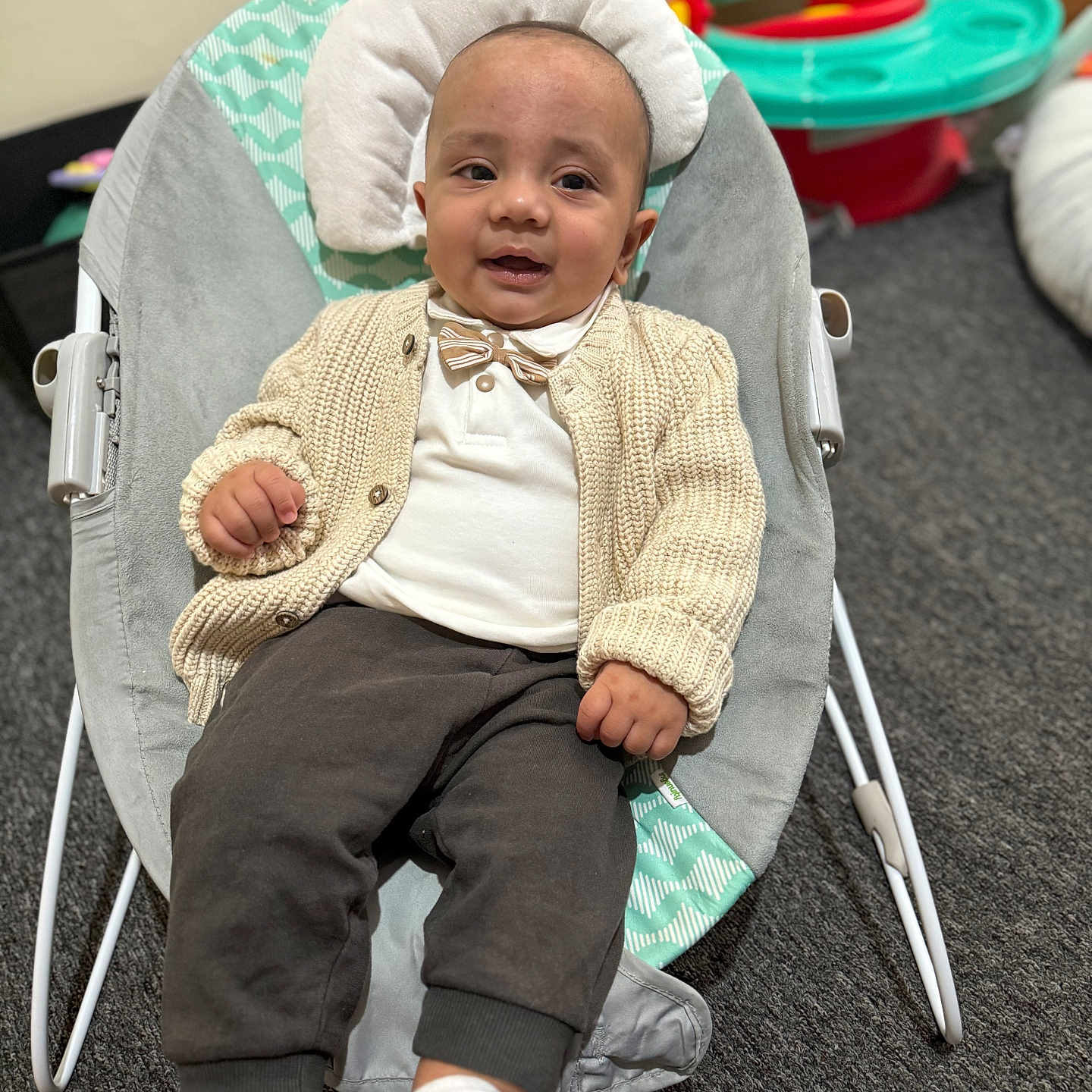 Gurbaaz joined the competition — help win amazing prizes! baby, baby_seat, bow_tie, cardigan, carpet, child, clothing, comfort, cozy, cute, floor, indoor, infant, person, play_area, seated, smile, socks, toy, young_child
