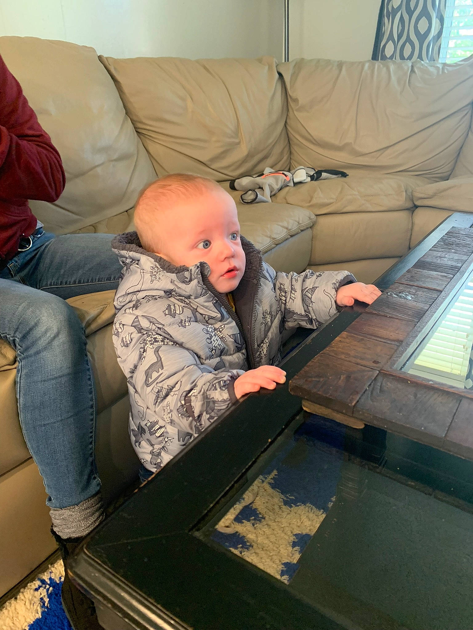 Lukas is registered to the contest to win money with this photo: baby, baby_toddler_clothing, child, comfort, couch, flooring, jeans, lap, military_camouflage, person, room, sitting, studio_couch, toddler, wood