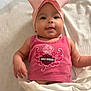 baby, infant, pink_bow, headband, tank_top, harley_davidson, tongue_out, blanket, white_blanket, diaper, cute, chubby_cheeks, smiling, lying_down, indoor, child, person, fashion, apparel, playful