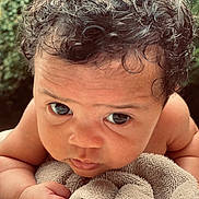 Beretta joined the competition — help win amazing prizes! baby, curly_hair, towel, close_up, infant, skin, face, eyes, arm, expression, outdoor, nature, portrait, child, cute, soft_texture, resting, young, person, photography