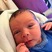 Siar participe au concours pour gagner de l'argent avec cette photo : baby, newborn, close_up, face, hand, blanket, blue_clothing, striped_clothing, indoor, soft_texture, cute, infant, portrait, human, skin, eyes, expression, cozy, background, resting