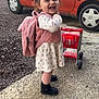 toddler, child, smiling, backpack, toy_cart, pigtails, pink, dress, boots, outdoor, car, concrete, gravel, happy, person, young_child, play, side_view, cute, fashion
