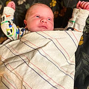 Jason joined the competition — help win amazing prizes! arms_up, baby, blanket, blue_eyes, clothing, cozy, curious, cute, face, floral_pattern, human, indoors, infant, lying_down, newborn, peaceful, portrait, small_hands, soft_texture, striped