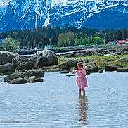 Scarlett joined the competition — help win amazing prizes! child, girl, water, rocks, mountains, snow, nature, outdoor, dress, reflection, forest, scenic, landscape, playful, summer, shallow_water, greenery, sky, calm, daytime