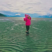 Sofie joined the competition — help win amazing prizes! beach, boots, child, cloudy_sky, cold_weather, horizon, isolated, landscape, mountains, nature, outdoor, pink_jacket, ripples, sand, scenic, spring, standing, text_overlay, water, winter_clothing