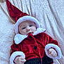 Albie-Joseph is registered to the contest to win money with this photo: baby, black_belt, blanket, blue_eyes, buttoned_jacket, christmas_costume, cozy, cute, face, festive, hand, holiday, indoor, infant, lying_down, portrait, red_clothing, santa_hat, soft_texture, white_fur_trim