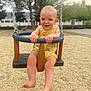 baby, child, swing, playground, outdoor, yellow_onesie, barefoot, happy, smiling, face, hands, legs, trees, bench, gravel, daylight, park, fun, summer, person