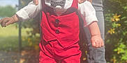 Julian a rejoint le concours — aidez-le/la à gagner de superbes lots ! toddler, child, boy, outdoor, sunlight, red_clothing, vest, pants, white_shoes, cap, bow_tie, person, adult_hands, supporting, walking, sidewalk, shoes, nature, plants, happy