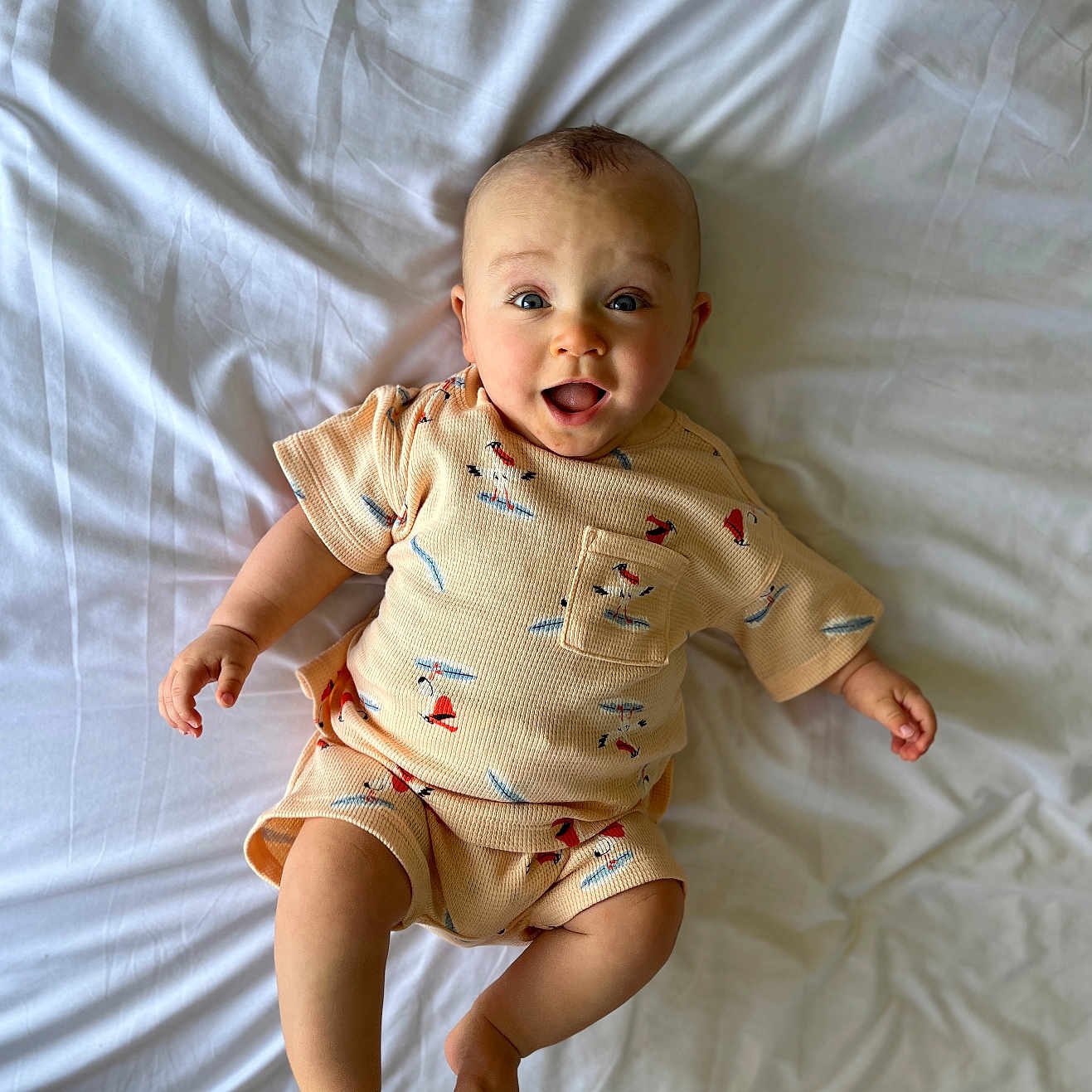 Grayson is registered to the contest to win money with this photo: baby, babylaughing, bodypart, clothing, couch, dress, face, finger, furniture, hand, happy, hardwood, head, newborn, person, photography, portrait, sitting, smile, wood