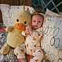 Lucas joined the competition — help win amazing prizes! baby, plush_toy, duck, pajamas, bed, pillow, pattern, infant, clothing, cute, child, soft_toy, smiling, indoors, sleepwear, person, resting, comfort, headboard, furniture
