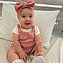 Maya joined the competition — help win amazing prizes! baby, infant, smiling, pink_bow, headband, knitted_romper, white_shirt, white_shoes, socks, bed, pillow, blanket, chubby_arms, chubby_legs, cute, happy, indoors, portrait, person, child