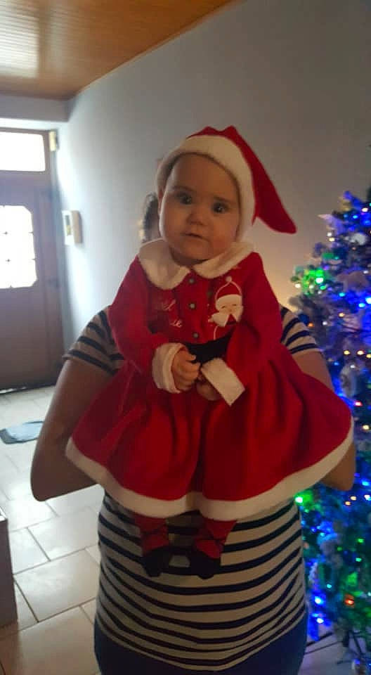 Arya participe au concours pour gagner de l'argent avec cette photo : child, christmas, christmas_decoration, christmas_eve, christmas_ornament, christmas_tree, costume, event, fictional_character, holiday, interior_design, outerwear, person, santa_claus, toddler, tree