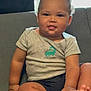 Amir joined the competition — help win amazing prizes! toddler, child, baby, sitting, couch, indoor, clothing, shirt, dinosaur, hand, feet, toes, face, smile, curly_hair, window, blinds, light, furniture, casual